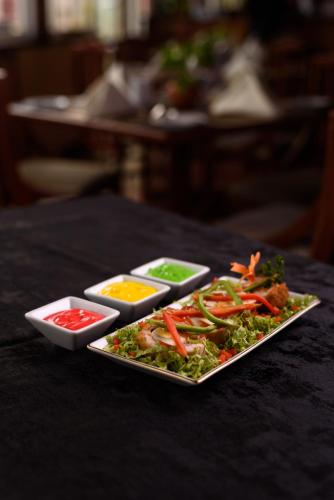 a plate of food with condiments on a table at Oak Ray Colombo City Hotel in Colombo