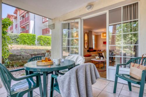 a room with a table and chairs on a patio at Résidence Pierre & Vacances Le Domaine de Gascogne in Biscarrosse