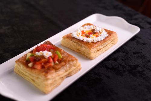 two pieces of toast with toppings on a white plate at Oak Ray Colombo City Hotel in Colombo