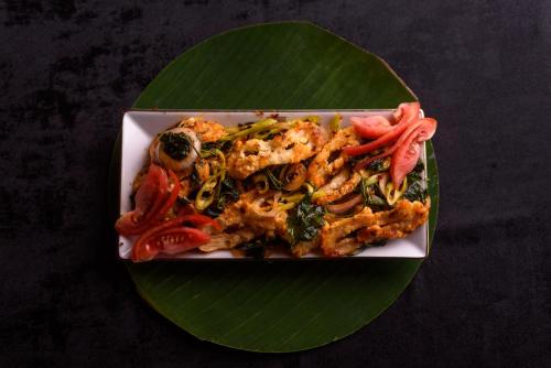 a plate of food on top of a green leaf at Oak Ray Colombo City Hotel in Colombo