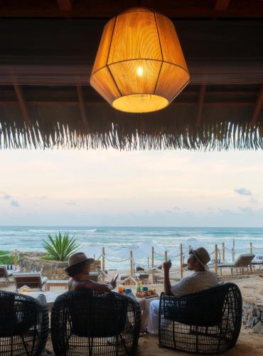 two men sitting at a table looking at the ocean at Cape Weligama - Relais and Chateaux in Weligama
