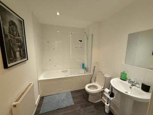 a white bathroom with a toilet and a sink at Comfy Premium Home in Town in Bracknell