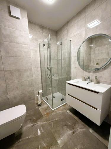a bathroom with a shower and a sink and a toilet at Justinrent PALATIUM 12 in Legnica