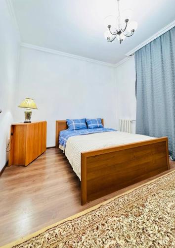 a bedroom with a bed and a chandelier at Международный Аэропорт Алматы Апартаменты "100 метров" in Almaty