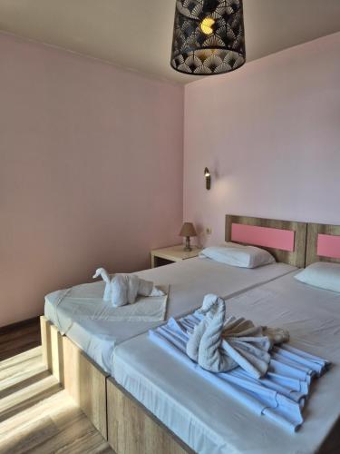 two beds in a room with towels on them at 365 studios - Close to the beach in Kavala