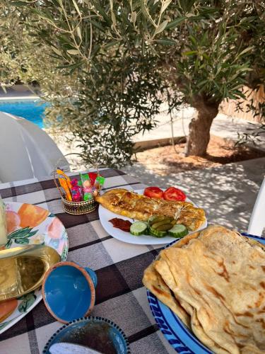 a table with plates of food on top of a table at Djerba 7 in Aghīr