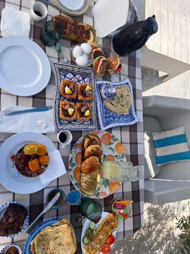 a picnic table with plates of food on it at Djerba 7 in Aghīr