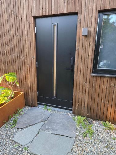 a black door on the side of a building at Modern 3-room, perfect base for experiences in Tromsø