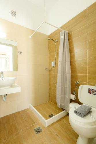 a bathroom with a shower and a toilet and a sink at Porto Greco Village Beach Hotel in Hersonissos