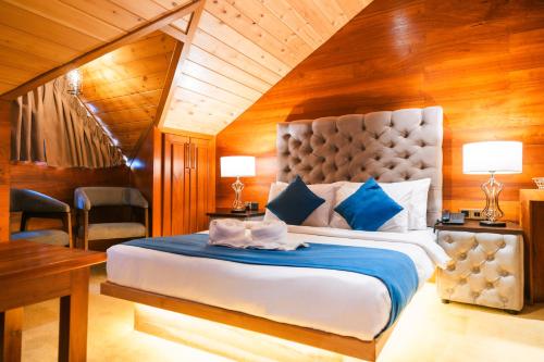 a bedroom with a large bed with a blue blanket at Baron Luxury Boutique in Nuwara Eliya