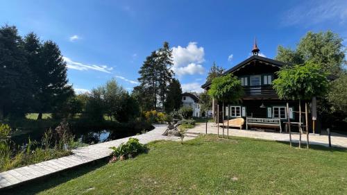 ein Haus mit einem Garten und einem Teich davor in der Unterkunft Landhaus Danner 
