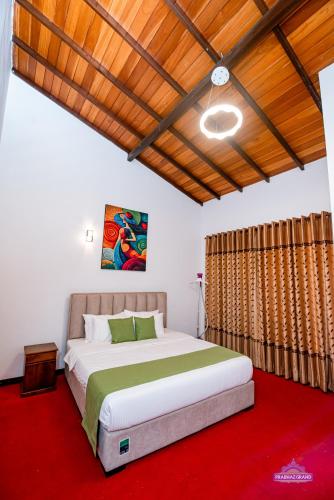 a bedroom with a large bed and a red carpet at Prabhaz Grand in Hatton
