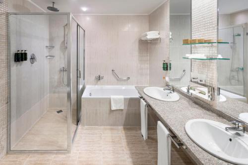 un bagno con due lavandini, una doccia e una vasca di Melia Grand Hermitage All Inclusive a Golden Sands