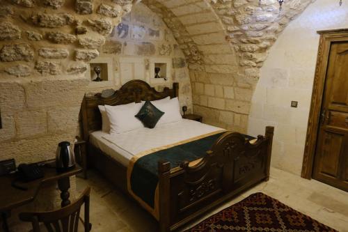 a bedroom with a bed in a stone room at Badgirli Konak in Urfa