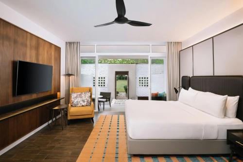 a bedroom with a bed and a flat screen tv at Lone Pine, Penang, a Tribute Portfolio Resort in Batu Ferringhi
