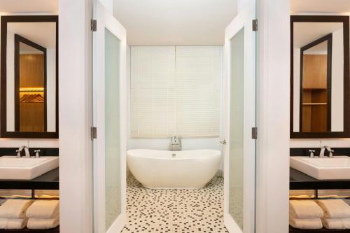 a bathroom with two sinks and a bath tub at Lone Pine, Penang, a Tribute Portfolio Resort in Batu Ferringhi
