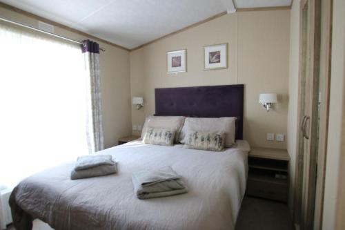 a bedroom with a large bed with two towels on it at Harbourside in Christchurch