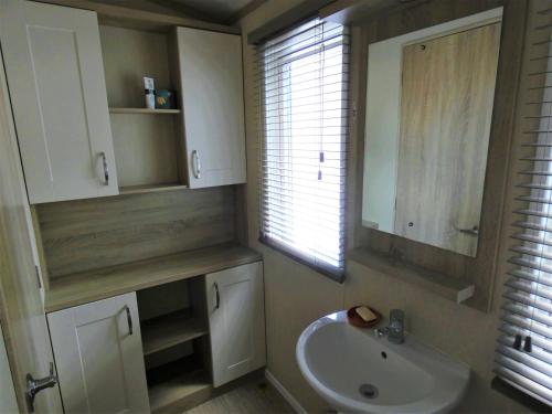 a bathroom with a sink and a mirror and a window at Harbourside in Christchurch