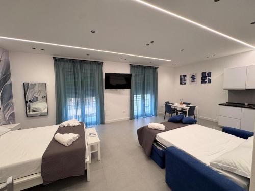 a hotel room with two beds and a desk at Meraviglia B&B - Salerno Centro Close to the Station and Pier in Salerno