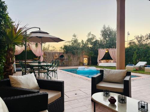 a patio with a table and chairs and a pool at Private Villa BSF - Hot Pool & Spa - Palm Golf in Marrakech