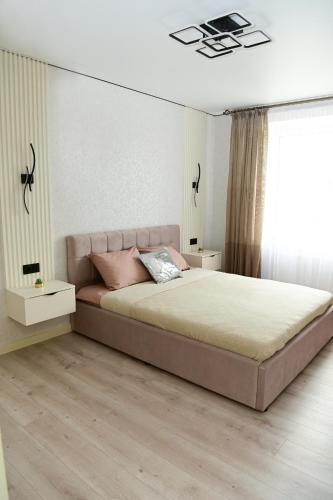 a bedroom with a large bed with pink pillows at Яровиця 9 новобуд in Lutsk