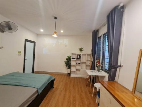 a bedroom with a bed and a desk and a window at Paradies Homestay in Hue