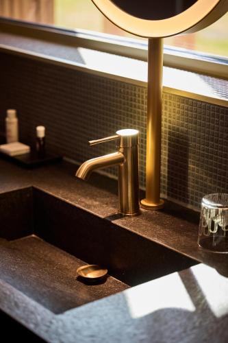 a sink in a bathroom with a mirror above it at Le Rêve - Hôtel Luxe in Mesnil-Saint-Père