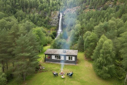a house in the middle of a forest with a waterfall at Waterfall Retreat in Sel