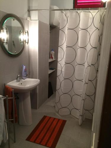 La salle de bains est pourvue d'une douche, d'un lavabo et d'un miroir. dans l'établissement Casa Vacanza, à Zafferana Etnea