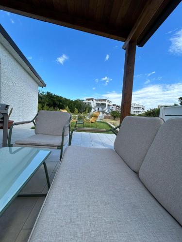 a patio with two chairs and a couch on a balcony at Villa Gisa in Calalunga-Pietragrande