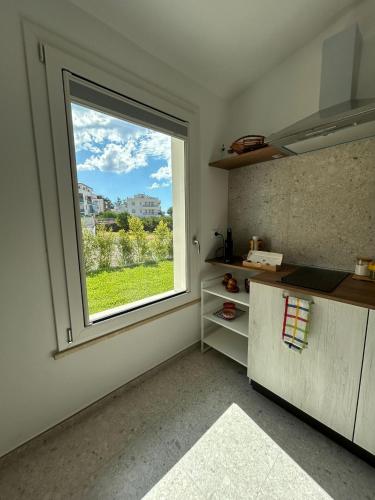 a kitchen with a large window in a room at Villa Gisa in Calalunga-Pietragrande
