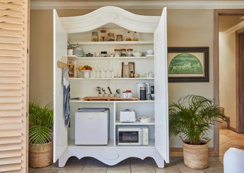 a white pantry with dishes and appliances in it at Villa del Mar - "Luxurious en-suite bedroom with lounge and stunning sea view balcony in Bantry Bay" in Cape Town