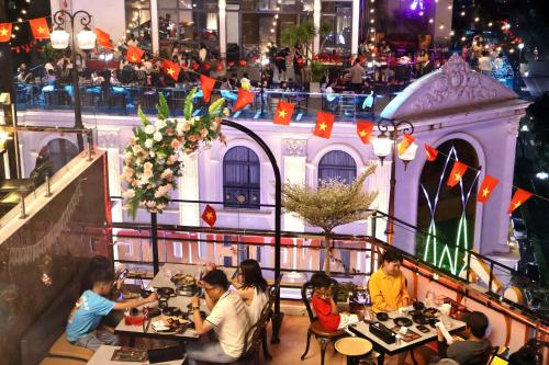 a group of people sitting at tables in a restaurant at B.O.B Hotel in Cao Lãnh