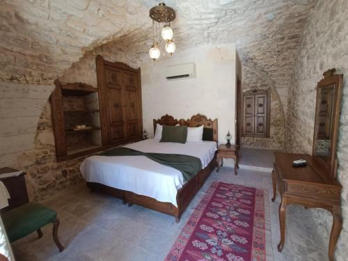una camera da letto con un letto e un tavolo in una stanza di Fırfırlı Konak a Şanlıurfa
