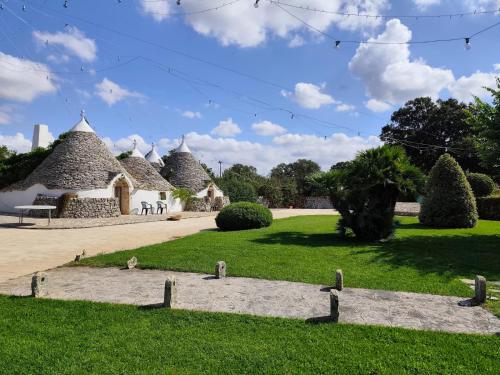 a group of huts in a park with grass at Tenuta Antico Leccio in Gioia del Colle
