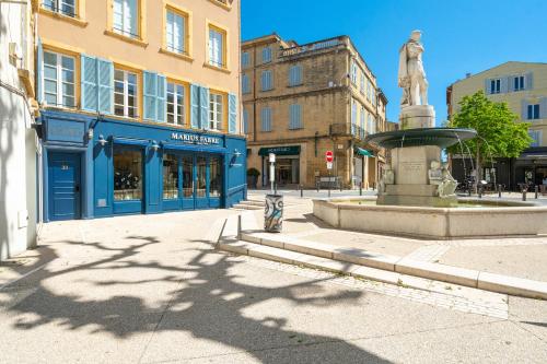 a fountain in the middle of a street with buildings at La Réserve de Salon de Provence in Salon-de-Provence