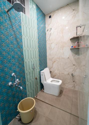 a bathroom with a toilet and a glass shower at Hanah's Cozy Stay Near SKCET Coimbatore in Coimbatore
