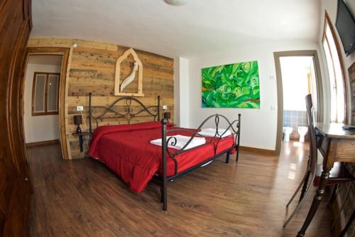 a bedroom with a red bed with a wooden wall at Le Perine 6 in Valdobbiadene