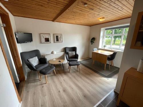 a living room with chairs and a table and a tv at Marskferie Tønder in Tønder