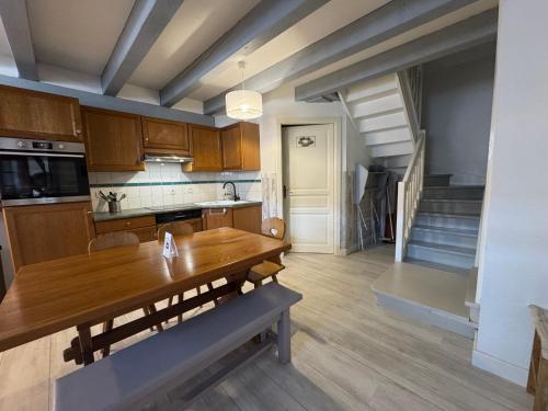a kitchen with a wooden table and a staircase at Relais du Dompeter in Molsheim
