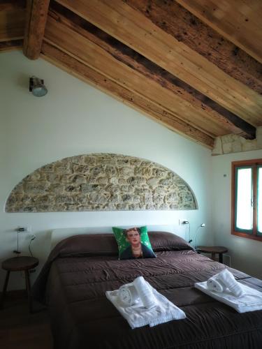 a bedroom with a large bed in a room with wooden ceilings at Le Perine 6 in Valdobbiadene