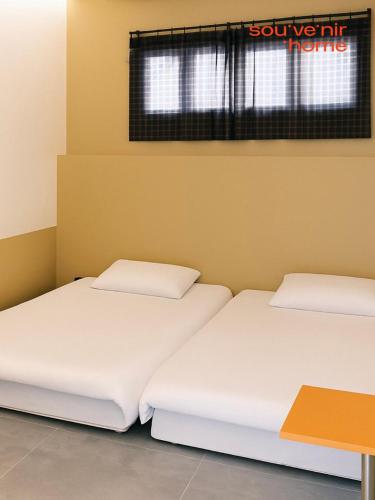 two beds sitting next to each other in a room at Terrace Rooftop Luggage Storage Spacious Two Rooms Beam Projector 4 Beds Jeonpo Seomyeon Busan Station in Busan