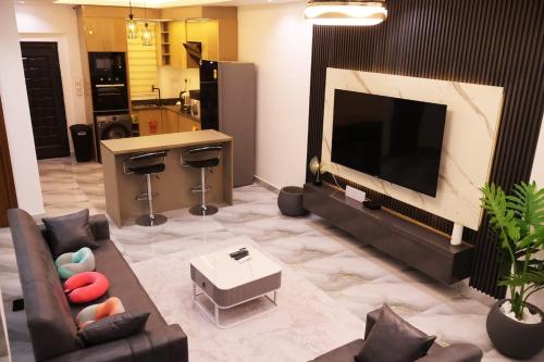 a living room with a couch and a flat screen tv at Apartment in Accra, East Legon in Trofwi