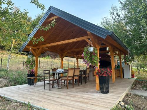 a wooden gazebo with a table and chairs at Apartments Daisy in Banja Luka
