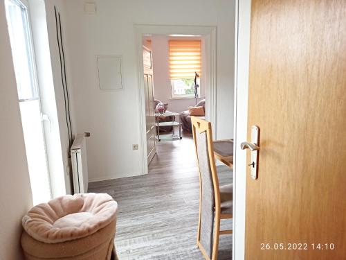 a hallway with a door and a room with a chair at Ferienwohnung Happy Life in Northeim
