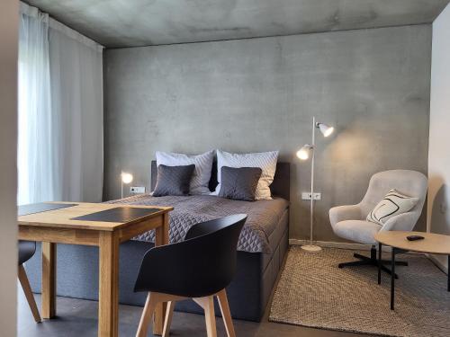 a bedroom with a bed and a table and chair at Apartment Schlossterrassen 8b in Pouch