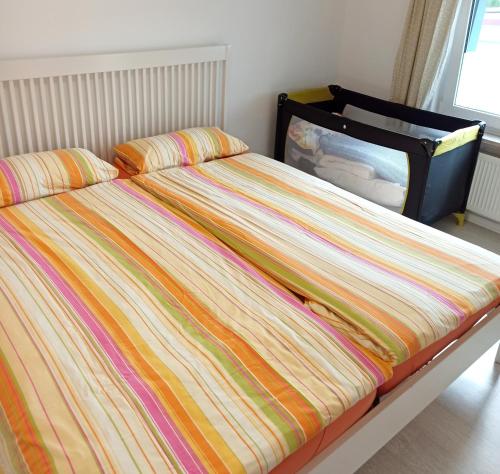 a bed with a colorful comforter and pillows on it at Ferienwohnung Happy Life in Northeim