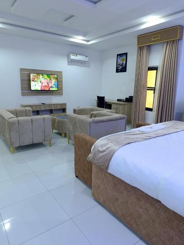 a hotel room with two beds and a living room at Immaculate Excellence Luxury Hotel in Owerri