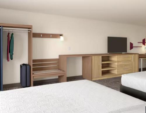 a hotel room with a bed and a tv and a bed and a tvicter at Home2 Suites By Hilton Muncie in Muncie