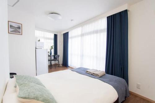 a bedroom with a white bed and a large window at c4F 浅草 上野商圈夏美ホテル 高级独栋别墅 独立卫浴 车站步行五分钟 成田羽田一线直通 in Tokyo